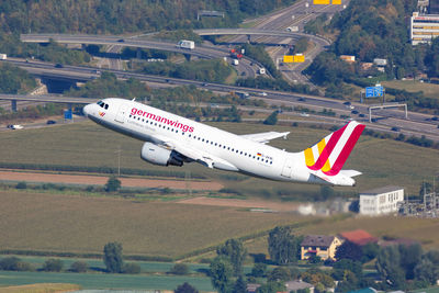 Airplane flying over land against sky