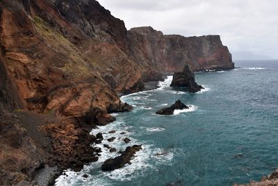 Rock formations by sea against sky