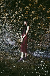 Midsection of woman standing by tree