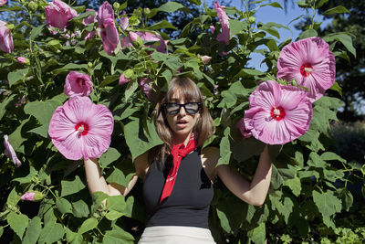 A young woman posing in front of a bush