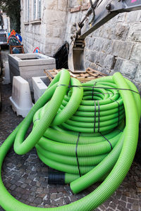 Stack of ropes on street against wall