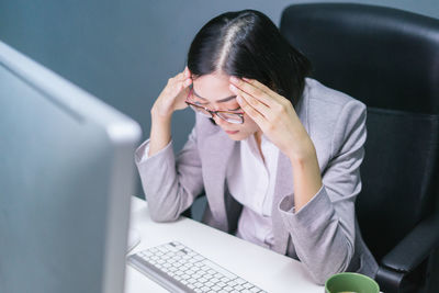 Midsection of woman using mobile phone while sitting on table