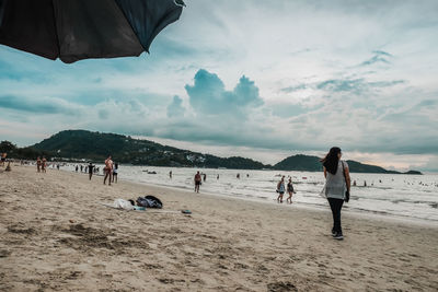 People at beach against sky