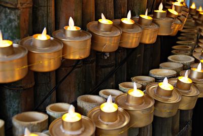 Lit oil lamps mounted on bamboo fence