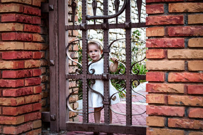 Portrait of boy standing by gate
