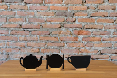 Close-up of empty table against brick wall
