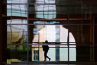 Reflection of people in glass building
