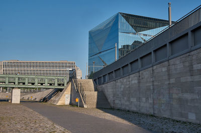 View of bridge and buildings against clear blue sky