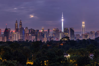 Illuminated buildings in city against sky