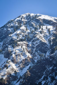 Aerial view of snowcapped mountains against clear sky