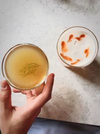 High angle view of hand holding drink on table