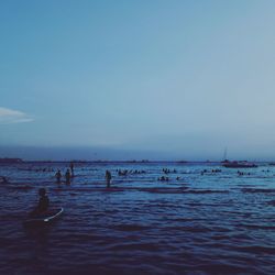 People enjoying in sea against sky