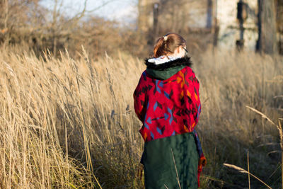 Rear view of woman standing on field during winter