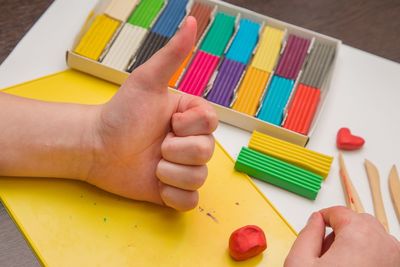 High angle view of hand holding pencils on table