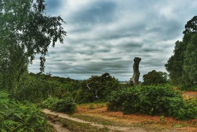 Statue against trees on landscape against sky