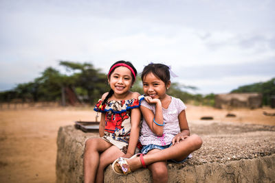 Portrait of a smiling girl sitting on land