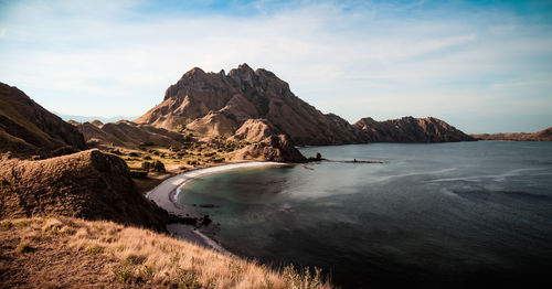 Scenic view of sea and mountains against sky