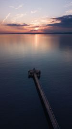 Scenic view of river against sky at sunset