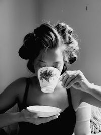 Young woman drinking coffee while sitting at home