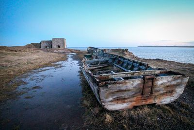 Abandoned boat at sea shore