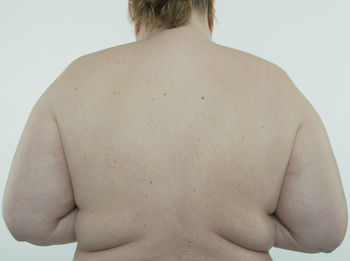 Rear view of shirtless man against white background