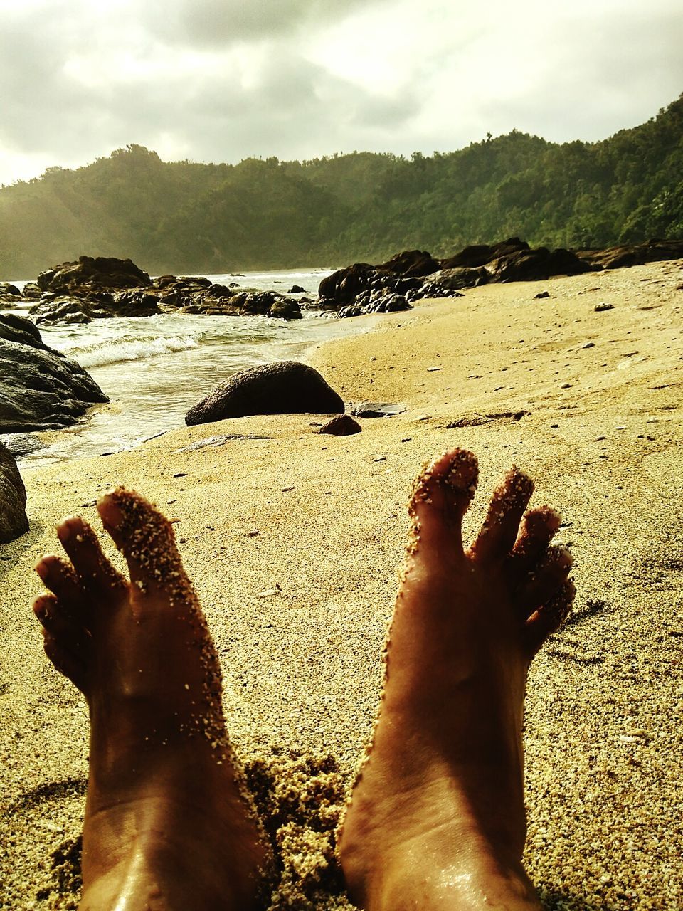 low section, beach, person, water, sand, personal perspective, barefoot, sea, lifestyles, leisure activity, shore, human foot, relaxation, sky, vacations, nature