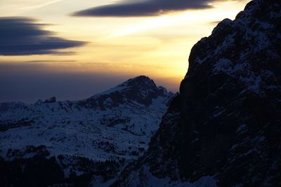 Scenic view of snowcapped mountains against sky during sunset