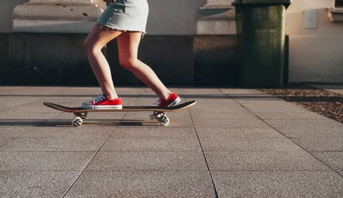 Low section of woman riding skateboard