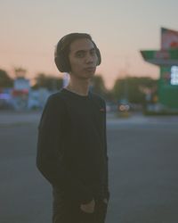 Portrait of young man standing on road