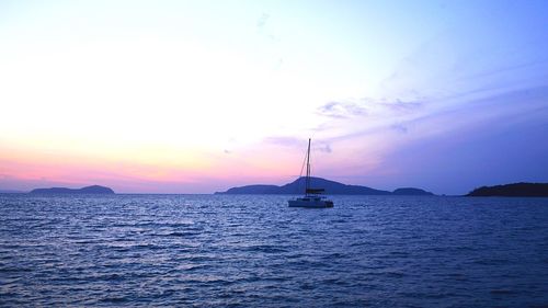 Sailboat sailing on sea against sky during sunset