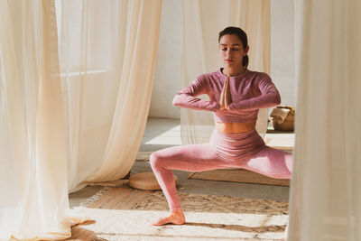 Portrait of young woman exercising at home
