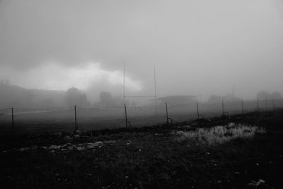 Scenic view of field against sky during foggy weather