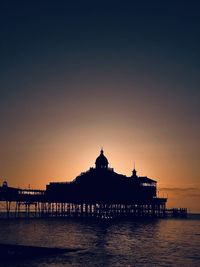 Silhouette of eastbourne pier at sunrise with clear skies