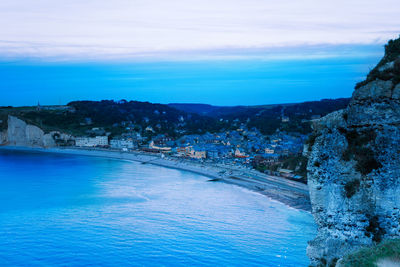 Scenic view of sea and mountains against blue sky