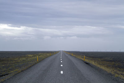 Empty road passing through field