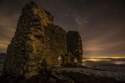 Low angle view of rock against sky at night