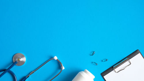 Low angle view of electric lamp against blue background