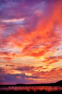 Scenic view of dramatic sky over silhouette landscape