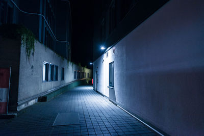 Narrow street amidst buildings at night