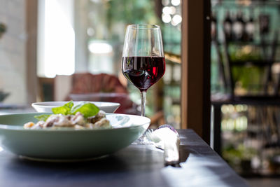 Close-up of red wine and food served on table