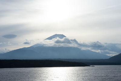 Scenic view of sea and mountains against sky