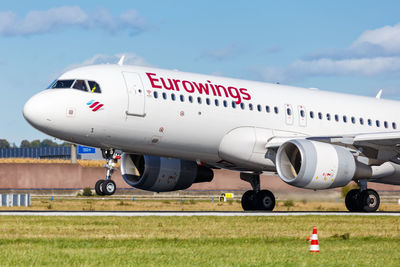 Airplane on airport runway against sky