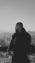 Side view of man standing against clear sky