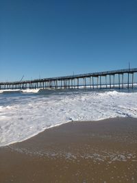 Bridge over sea against clear sky