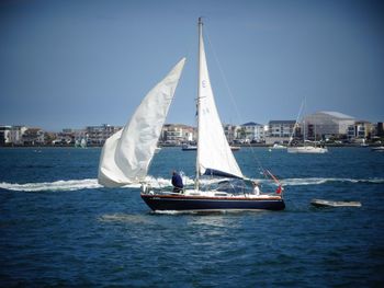 Sailboat sailing on sea against sky