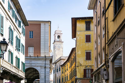 Low angle view of buildings in town against sky