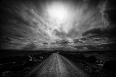 Empty road on field against sky