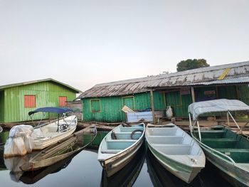 Boats moored by buildings against clear sky