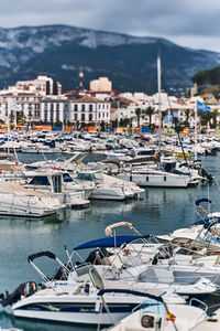 Boats moored in harbor against buildings in city