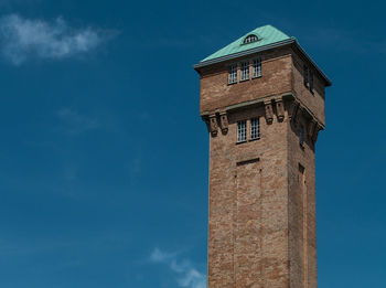 Low angle view of clock tower against blue sky